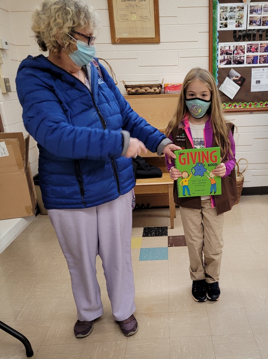 Members of Girl Scout Troop #90794 show off their copies of The Giving Book, donated by ASW Global.