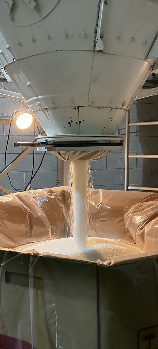 Polymer pours out of a silo at ASW Global into a bulk container.
